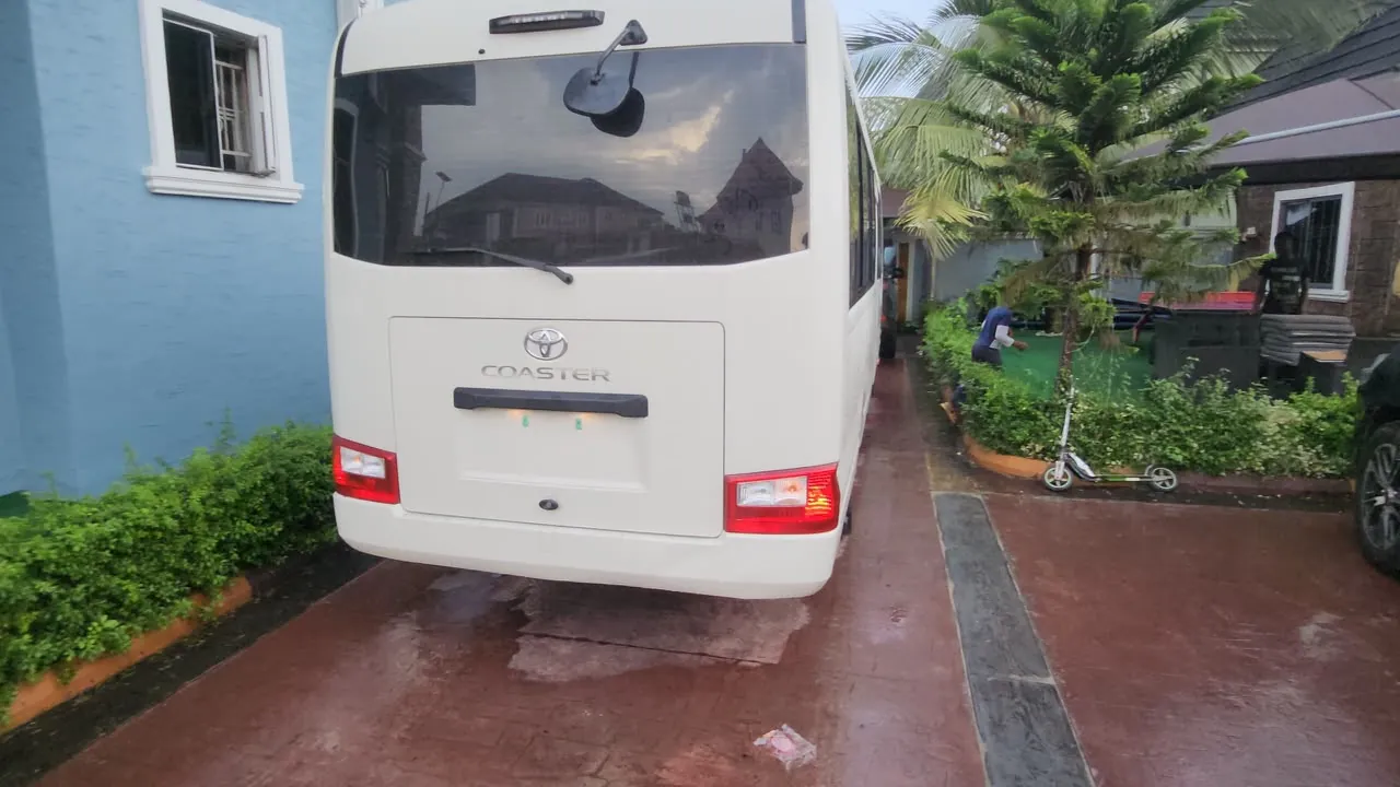 Rear view of a white Toyota Coaster bus showing the Coaster badge