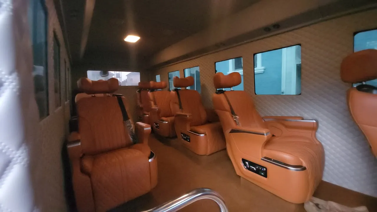 Coaster VIP interior with tan leather reclining seats and quilted wall panels