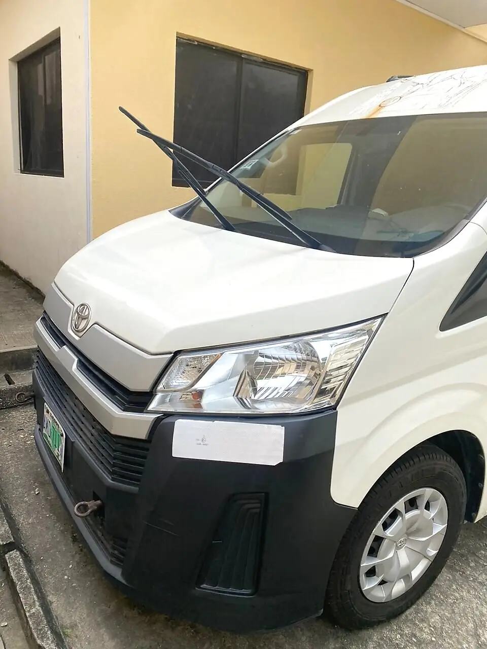 Front view of the Hiace bus parked outside a building, available for Hiace rental in Obalende, Lagos
