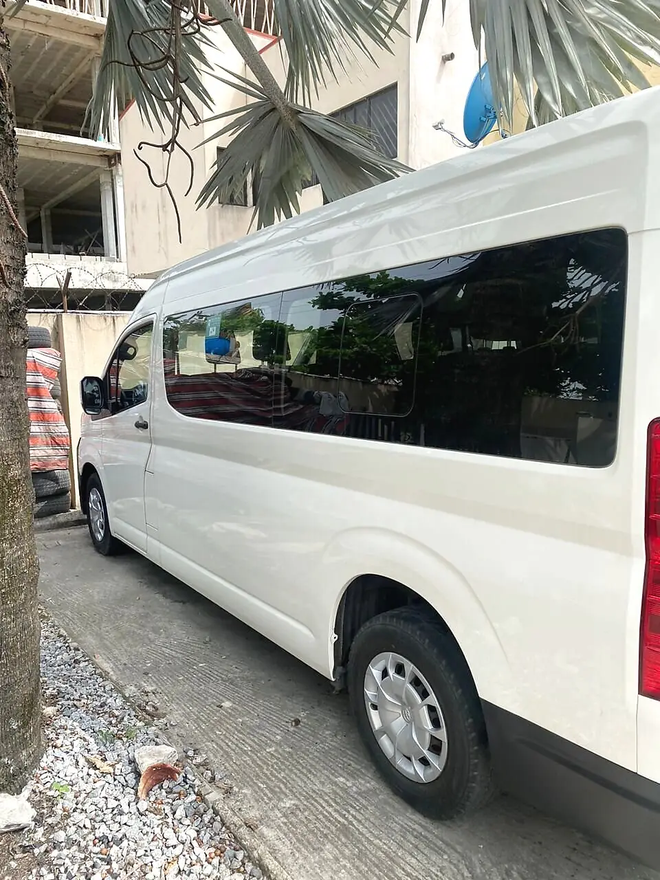 Side view of the Hiace bus showing tinted passenger windows, available for Hiace rental in Command, Lagos