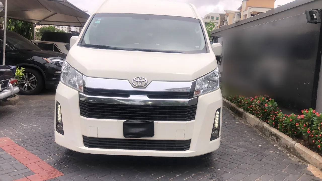 White Toyota Hiace bus, front view with chrome grille, in Lagos