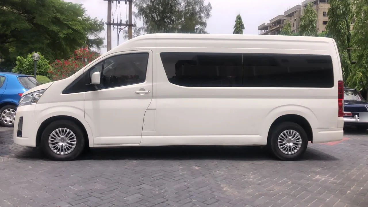 White high-roof Toyota Hiace bus for hire in Lagos, side profile